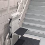 Plateautraplift type Omega met opklapbaar stoeltje.